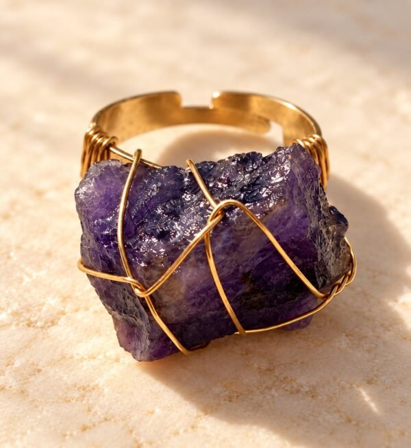 Bague roche améthyste Intuition en améthyste brute sertie de fil doré, vue de face sur marbre