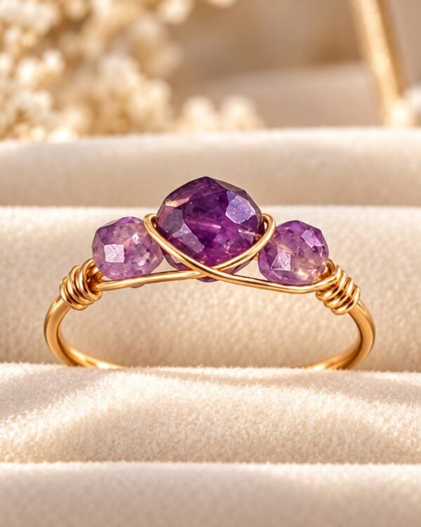Bague mini Intuition, trois perles d'améthyste facettées sur fil doré, sur velours