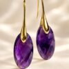 Boucles d'oreilles goutte en améthyste ovale facettée sur crochets dorés, fond clair