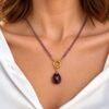 Collier améthyste goutte porté sur une chemise blanche ouverte