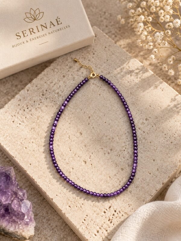 02-collier-perles-fines-amethyste Collier perles fines améthyste INTUITION posé sur dalle travertin, finition plaqué or, boîte Serinaé et améthyste brute