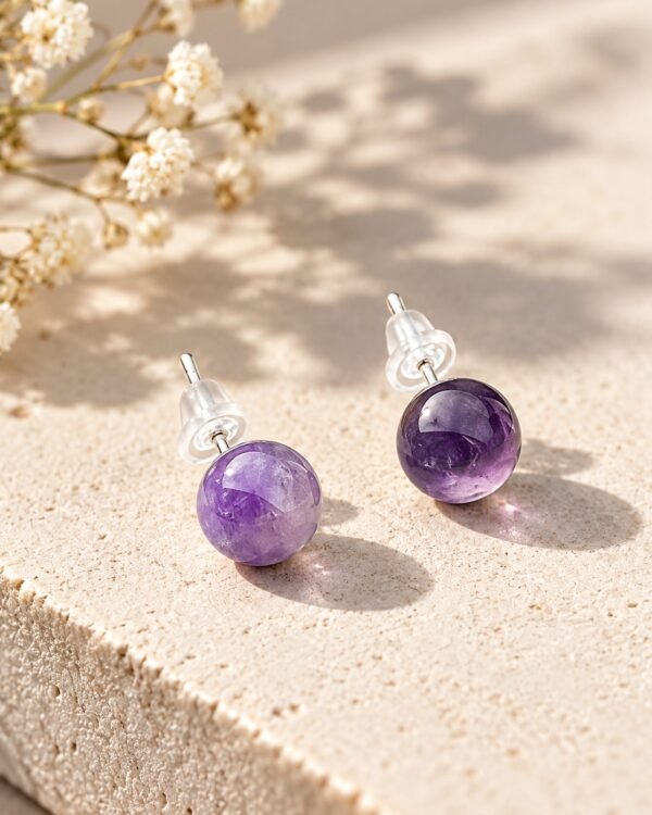 Paire de puces améthyste INTUITION, boules polies lilas à violet, sur dalle claire avec fleurs séchées