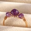 Bague mini Intuition en améthyste facettée posée sur velours crème