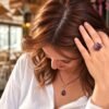 Bague roche améthyste Intuition en améthyste portée, main dans les cheveux, chemise blanche