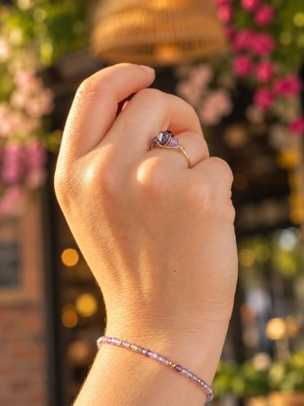 Bague mini Intuition en améthyste portée, poignet orné d'un bracelet améthyste