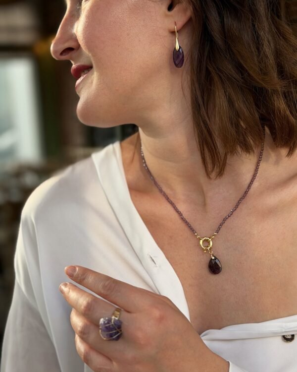 Boucle d'oreille améthyste goutte portée avec un collier assorti