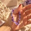 Bracelet élastique éclats d'améthyste dans la main, devant la boîte Serinaé
