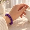 Bracelet perles d'améthyste 8 mm porté au poignet, tasse de café à la main