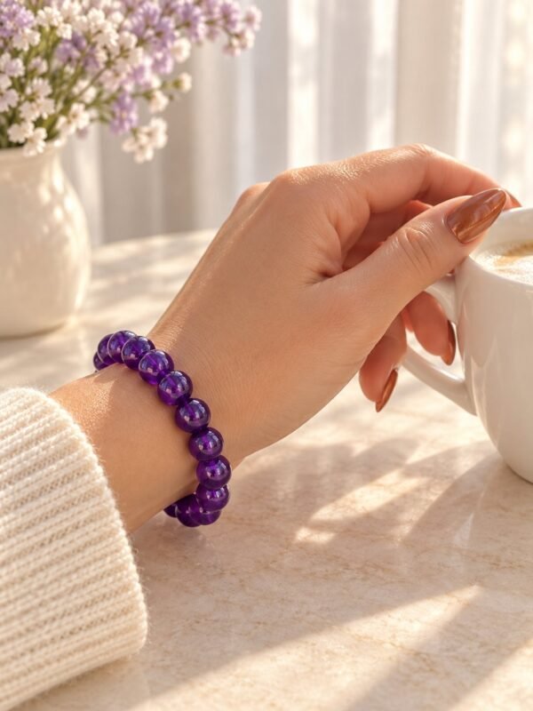 Bracelet perles d'améthyste 8 mm porté au poignet, tasse de café à la main