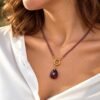 Collier en perles d'améthyste et pendentif goutte porté avec une chemise blanche