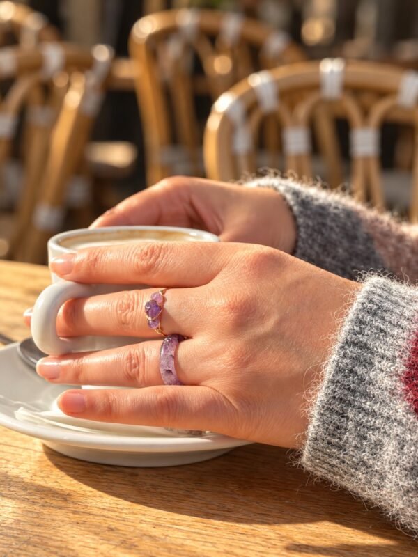 Bague mini Intuition en améthyste portée en terrasse, tasse de café à la main