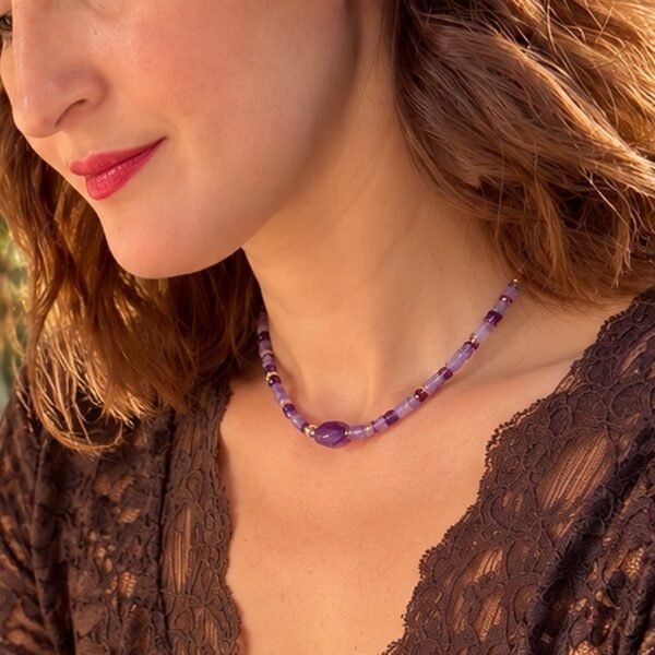 Collier perles améthyste INTUITION porté sur une tenue en dentelle marron, pierre centrale facettée visible