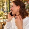 Bague roche améthyste Intuition en améthyste portée en terrasse, téléphone à la main