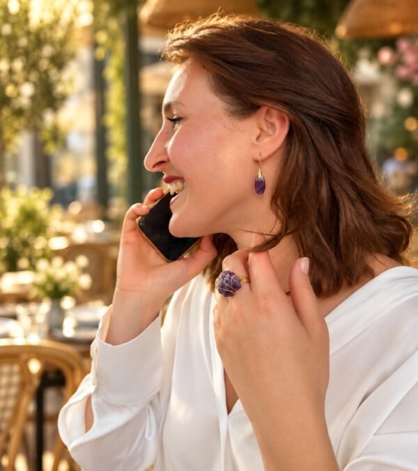 Bague roche améthyste Intuition en améthyste portée en terrasse, téléphone à la main