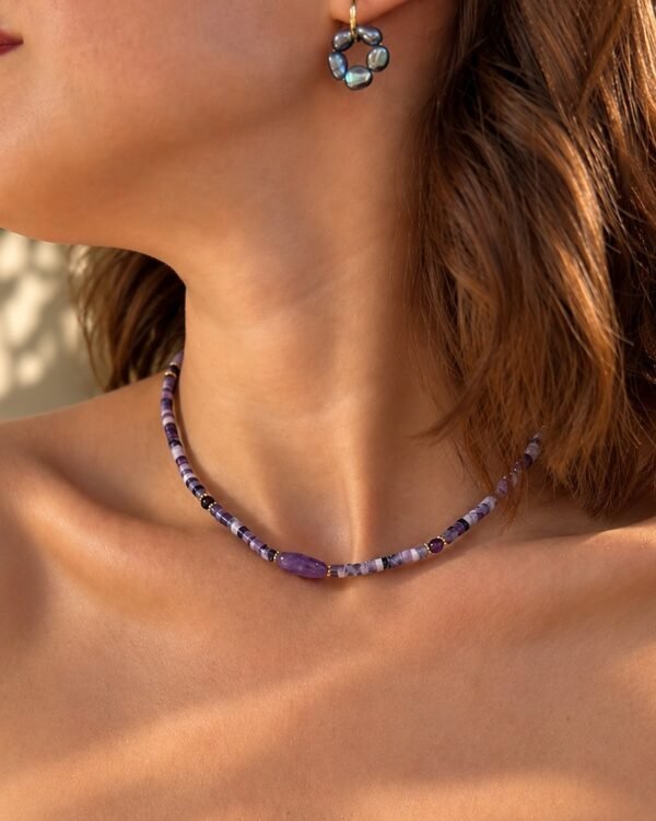 Gros plan du collier améthyste porté, nuances lilas et violettes, vue de trois quarts sur le décolleté