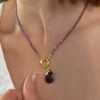 Détail des perles d'améthyste facettées et de la goutte du collier porté