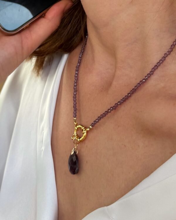 Collier améthyste à anneau doré et pendentif goutte porté, vue rapprochée