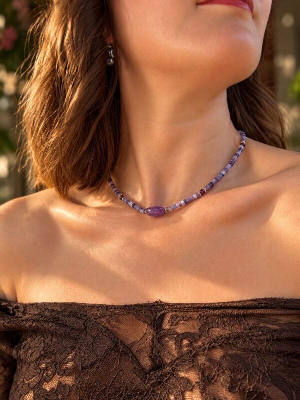 Collier perles améthyste INTUITION porté en extérieur, pierre centrale facettée et lumière naturelle