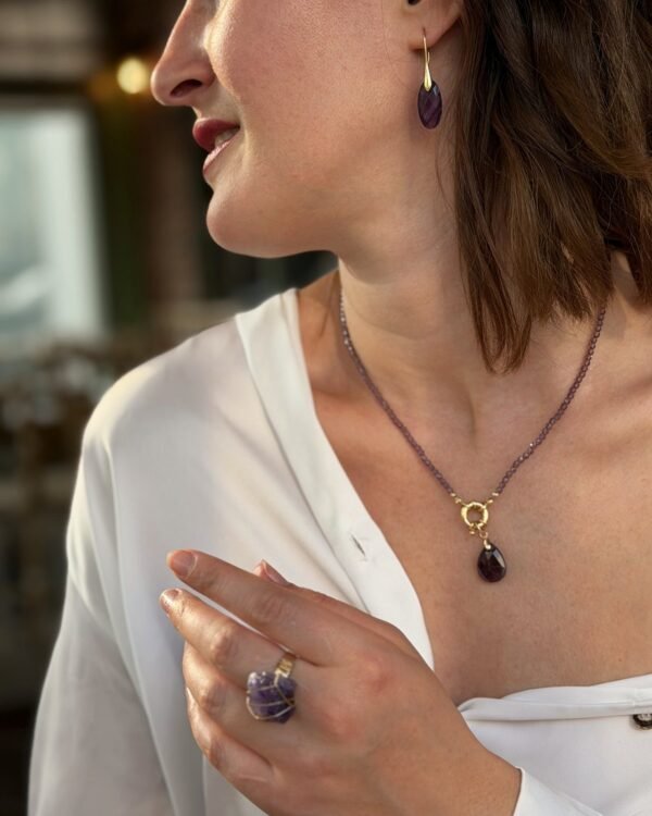 Bague roche améthyste Intuition en améthyste portée avec un collier goutte assorti