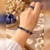 Bague AZUR en sodalite portée à la main avec un bracelet en éclats de sodalite