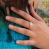 Bague AZURA – amazonite 4 Bague AZURA amazonite portée, main posée sur des plumes turquoise