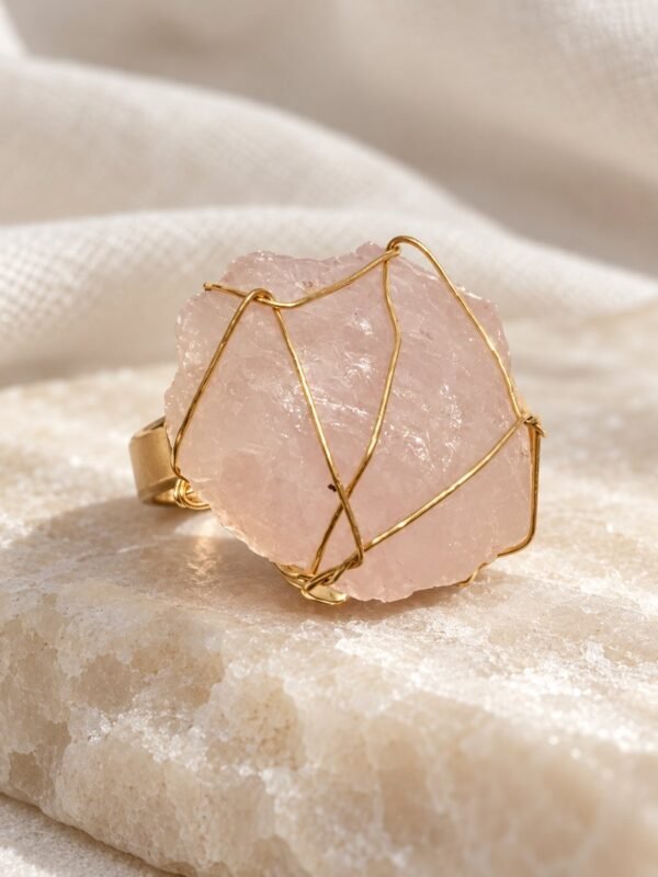 Bague brute en quartz rose naturel enlacée de fil, finition ton or, gros plan sur la pierre – vue 2