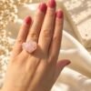 Bague brute en quartz rose naturel enlacée de fil, finition ton or, portée à la main – vue 5