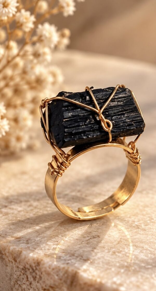 Bague brute en tourmaline noire naturelle enlacée de fil, finition ton or, posée sur pierre claire – vue 2
