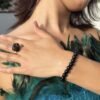 Bague brute en tourmaline noire naturelle enlacée de fil, finition ton or, portée à la main – vue 4