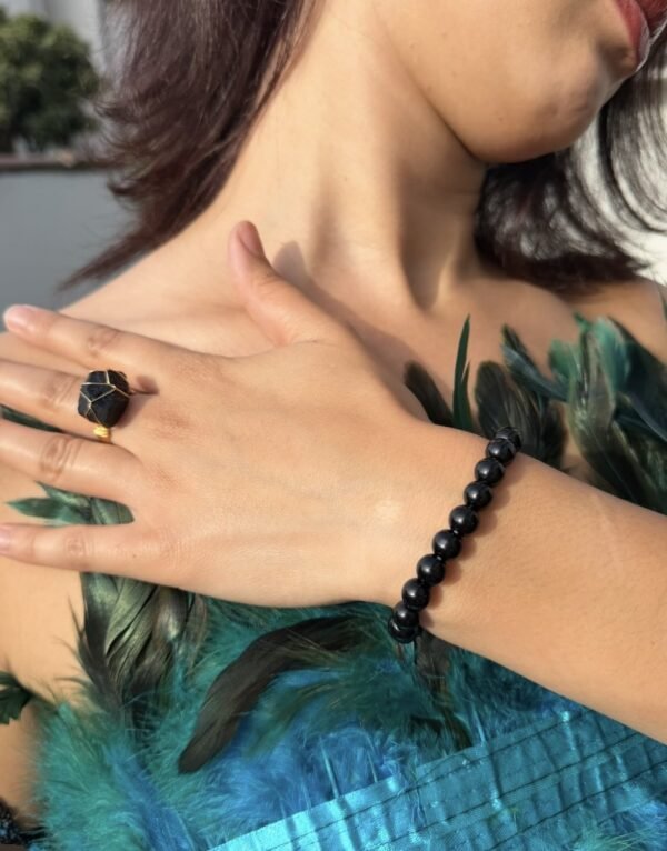 Bague brute en tourmaline noire naturelle enlacée de fil, finition ton or, portée au doigt – vue 6