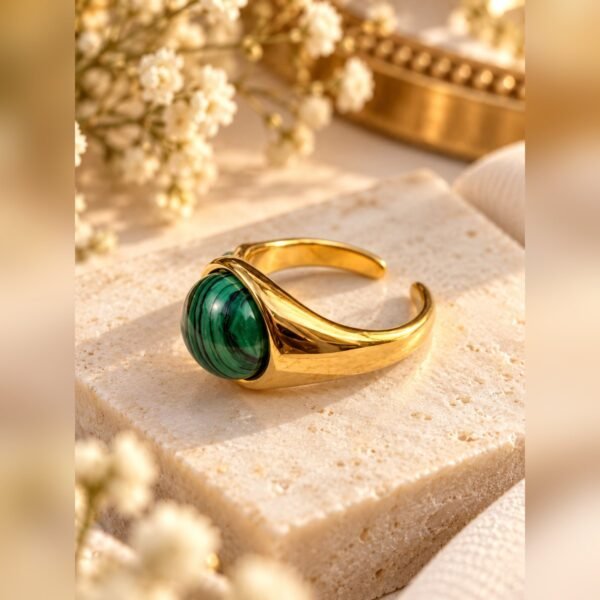 Bague MALYA en malachite posée sur une pierre claire avec gypsophile