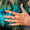 Bague mini AVENTURINE portée, main posée sur un haut en plumes turquoise – vue 4