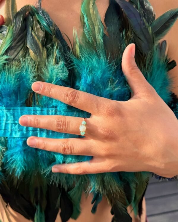 Bague mini AVENTURINE portée, main posée sur un haut en plumes turquoise – vue 4