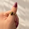 Bague SOLÉNA œil de tigre 6 Bague SOLÉNA portée au pouce, monture réglable aux finitions dorées – Serinaé