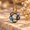 Boucle d’oreille ÉPURE Noire en perles d’eau douce noires aux reflets irisés, posée sur pierre claire – vue 2