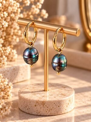 boucles-epure-perles-noires-baroques-1 Boucles d’oreilles ÉPURE, grosses perles d’eau douce baroques noires aux reflets bleutés sur créoles finition ton or, présentées sur un support – vue 1