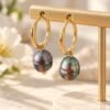 Boucles d’oreilles ÉPURE perles noires baroques irisées suspendues à un présentoir doré – vue 3