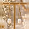Boucles d’oreilles ÉPURE – Perle 2 Boucles d’oreilles ÉPURE suspendues à un présentoir en T, gros plan sur la perle – Serinaé