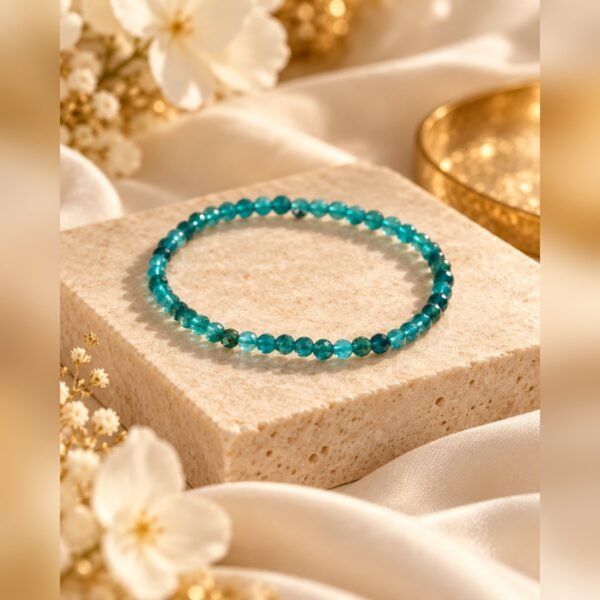 Bracelet en apatite turquoise posé sur un bloc de pierre près d’une coupelle