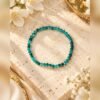 Bracelet en apatite bleu turquoise présenté à plat sur une pierre claire