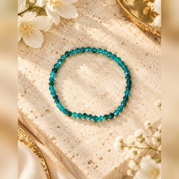Bracelet en apatite bleu turquoise présenté à plat sur une pierre claire