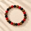 Bracelet FORCE & ÉNERGIE – obsidienne, agate rouge et œil de tigre 2 Bracelet FORCE & ÉNERGIE vu de dessus : perles rondes rouges, noires et œil de tigre aux reflets dorés