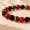 Bracelet FORCE & ÉNERGIE – obsidienne, agate rouge et œil de tigre 3 Détail des perles brillantes d’agate rouge, d’obsidienne noire et d’œil de tigre du bracelet FORCE & ÉNERGIE