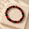 Bracelet FORCE & ÉNERGIE – obsidienne, agate rouge et œil de tigre 4 Bracelet en perles d’obsidienne, d’agate rouge et d’œil de tigre FORCE & ÉNERGIE posé sur une pierre