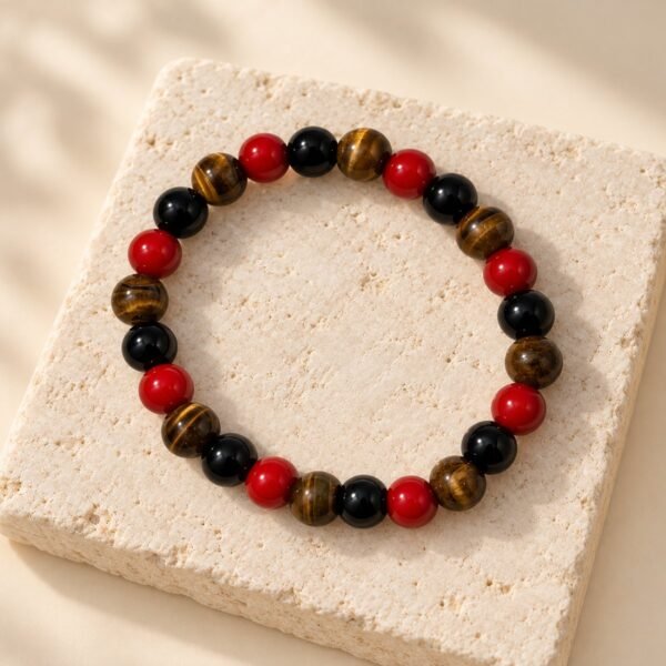 Bracelet FORCE & ÉNERGIE – obsidienne, agate rouge et œil de tigre 4 Bracelet en perles d’obsidienne, d’agate rouge et d’œil de tigre FORCE & ÉNERGIE posé sur une pierre