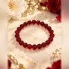 bracelet garance intense grenat 8mm Bracelet GARANCE INTENSE en perles rondes de grenat naturel 8 mm, rouge rubis à bordeaux, posé sur marbre avec des roses – Serinaé