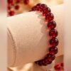bracelet garance intense grenat porte poignet Bracelet GARANCE INTENSE en grenat naturel sur fil élastique, présenté sur coussin à bracelet – Serinaé