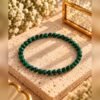 Bracelet MALYA malachite 2 Bracelet élastique en malachite naturelle 4 mm près d’une boîte en verre dorée