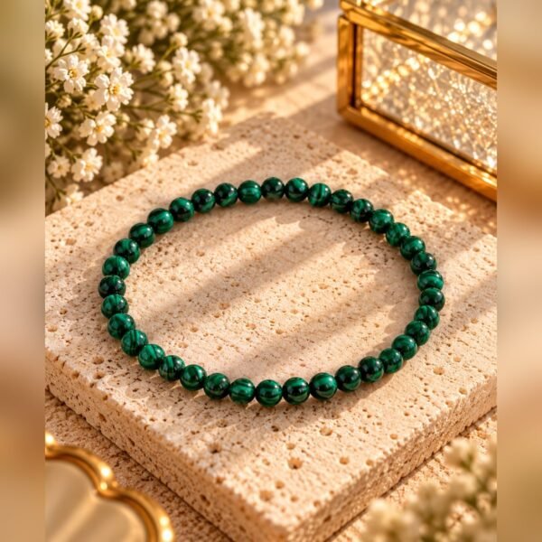 Bracelet MALYA malachite 2 Bracelet élastique en malachite naturelle 4 mm près d’une boîte en verre dorée