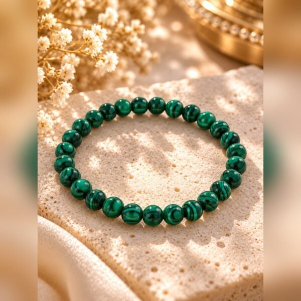 bracelet-malya-malachite-8mm Bracelet MALYA en malachite naturelle à perles de 8 mm posé sur un bloc de pierre
